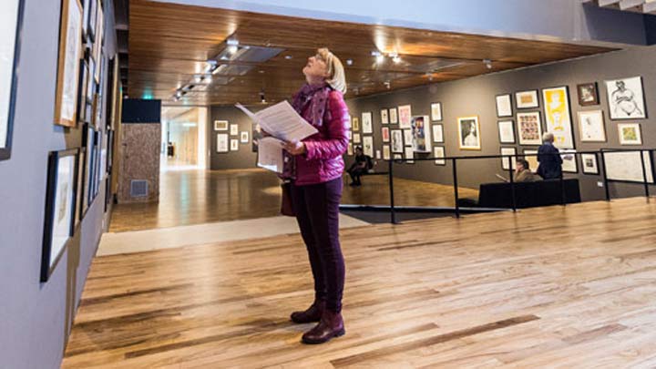 Woman looking at paintings in gallery