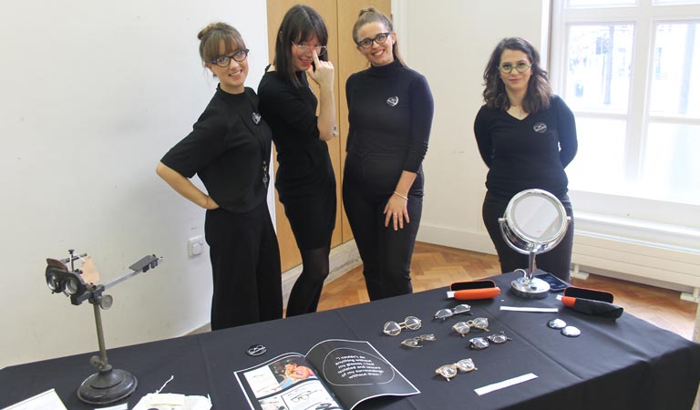 Four of our students demonstrate various sets of spectacles and other ophthalmic equipment.